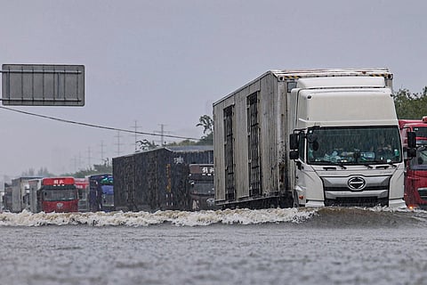 Vehicles drive through a flood waters in Shenyang